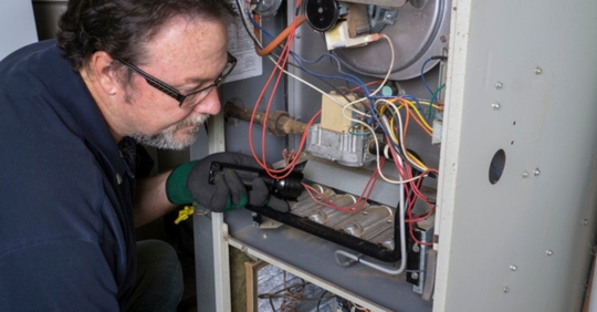 technician performing furnace maintenance